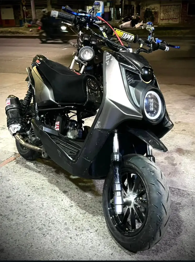 Scooter modificada con luz LED, escape y carbono